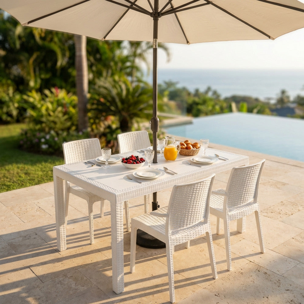 Tavolo da giardino Houston in wicker bianco allestito per la colazione a bordo piscina con ombrellone aperto.