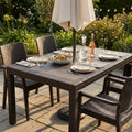 Tavolo da giardino Houston in wicker marrone allestito per un pranzo all'aperto con sedute coordinate e ombrellone.