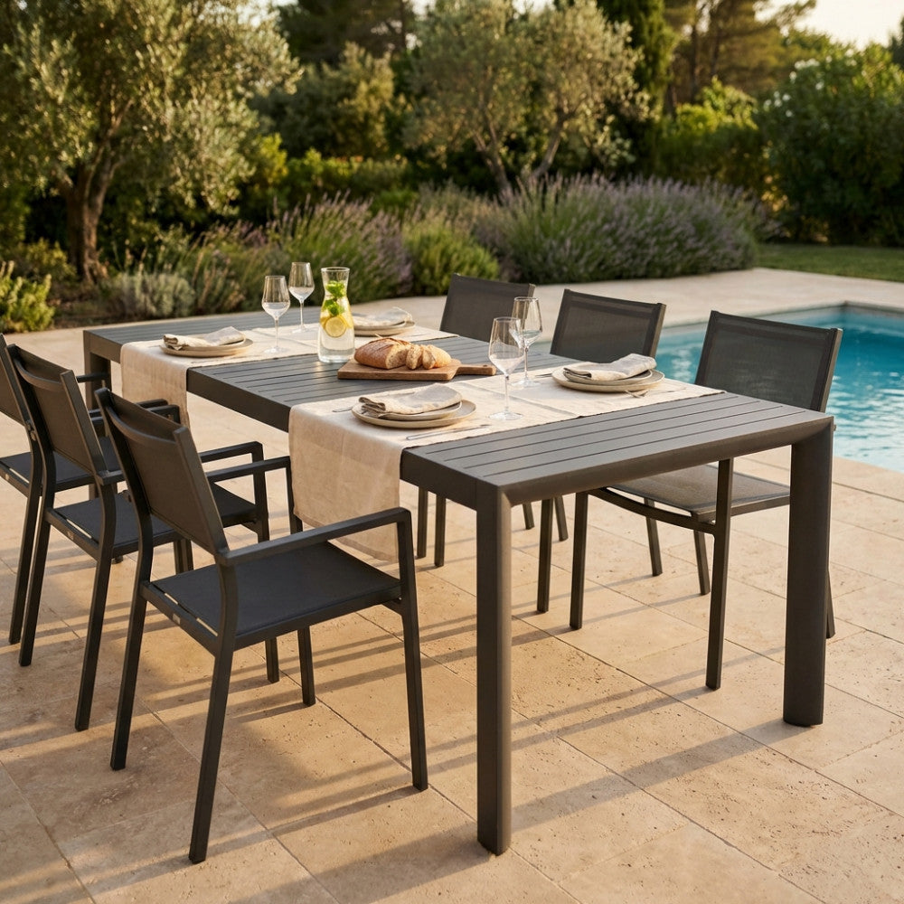 Dettaglio del tavolo Houston in alluminio con sedute abbinate e mise en place elegante su una terrazza soleggiata.