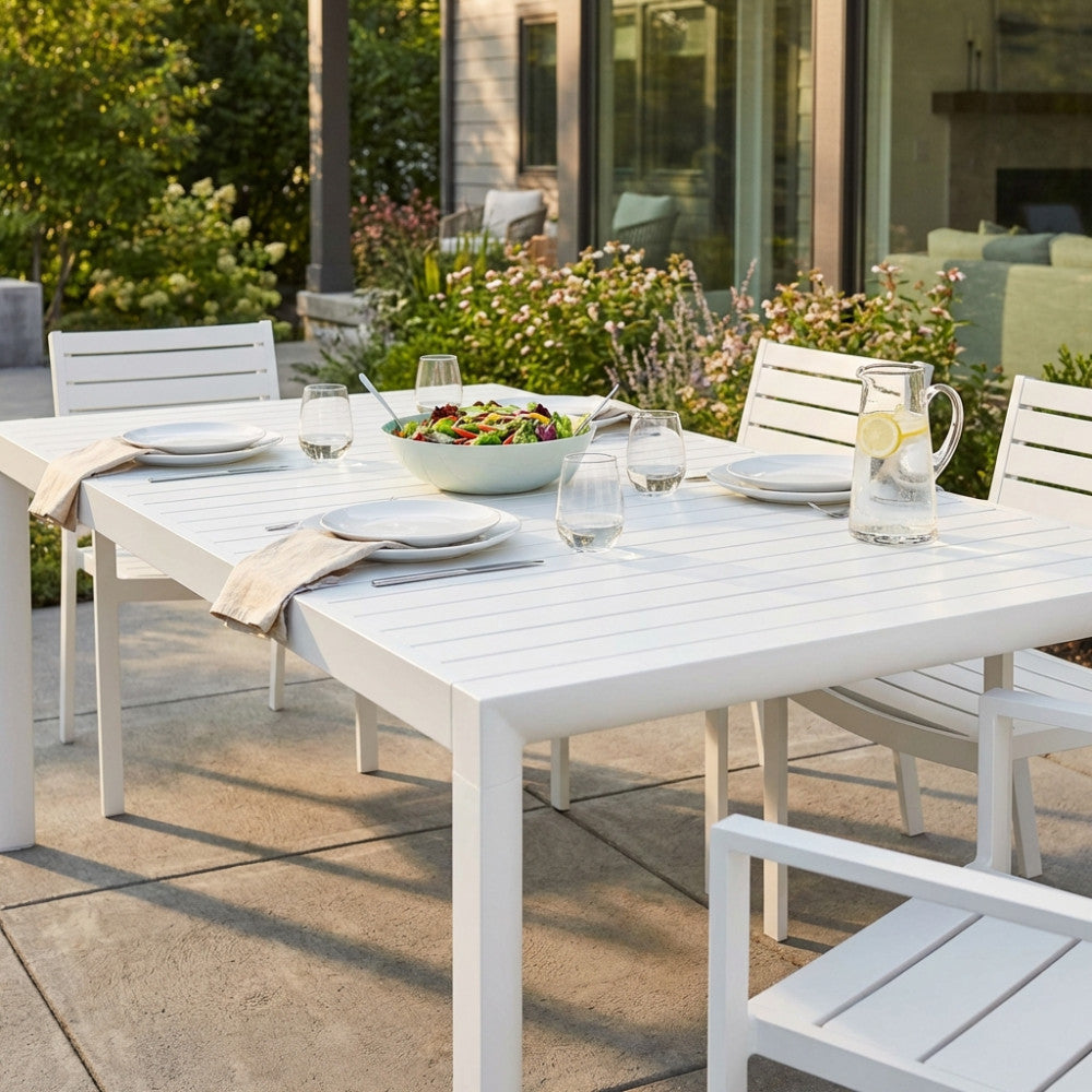 Dettaglio del tavolo da giardino Houston in alluminio bianco apparecchiato per un pranzo all'aperto.