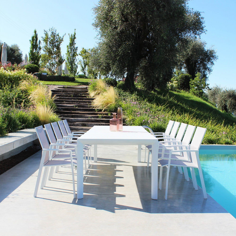 Tavolo da giardino Houston in alluminio bianco a bordo piscina con sedie abbinate e vista panoramica.