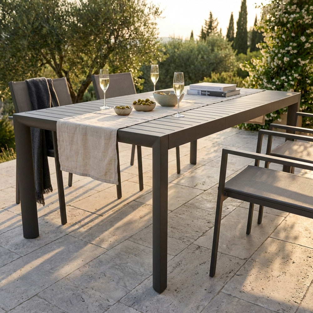 Tavolo da giardino allungabile Houston in alluminio taupe allestito per un aperitivo all'aperto.