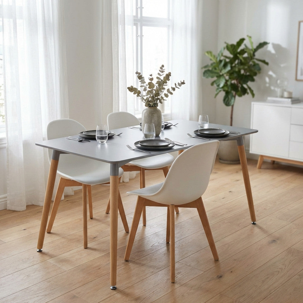 Tavolo da pranzo Lione grigio allestito in una luminosa sala moderna con quattro sedie bianche.