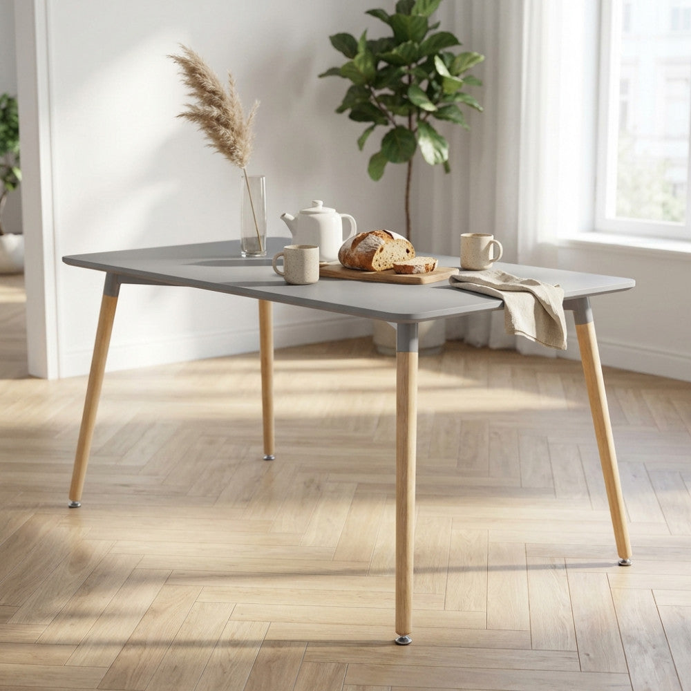 Dettaglio del tavolo Lione grigio decorato con pane artigianale, teiera e un vaso con pampas.