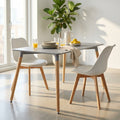 Tavolo da pranzo Lione grigio 140x80 cm ambientato in una sala da pranzo luminosa con sedie bianche e bicchieri di succo.