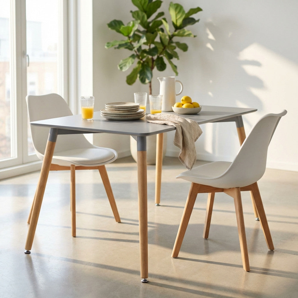 Tavolo da pranzo Lione grigio 140x80 cm ambientato in una sala da pranzo luminosa con sedie bianche e bicchieri di succo.