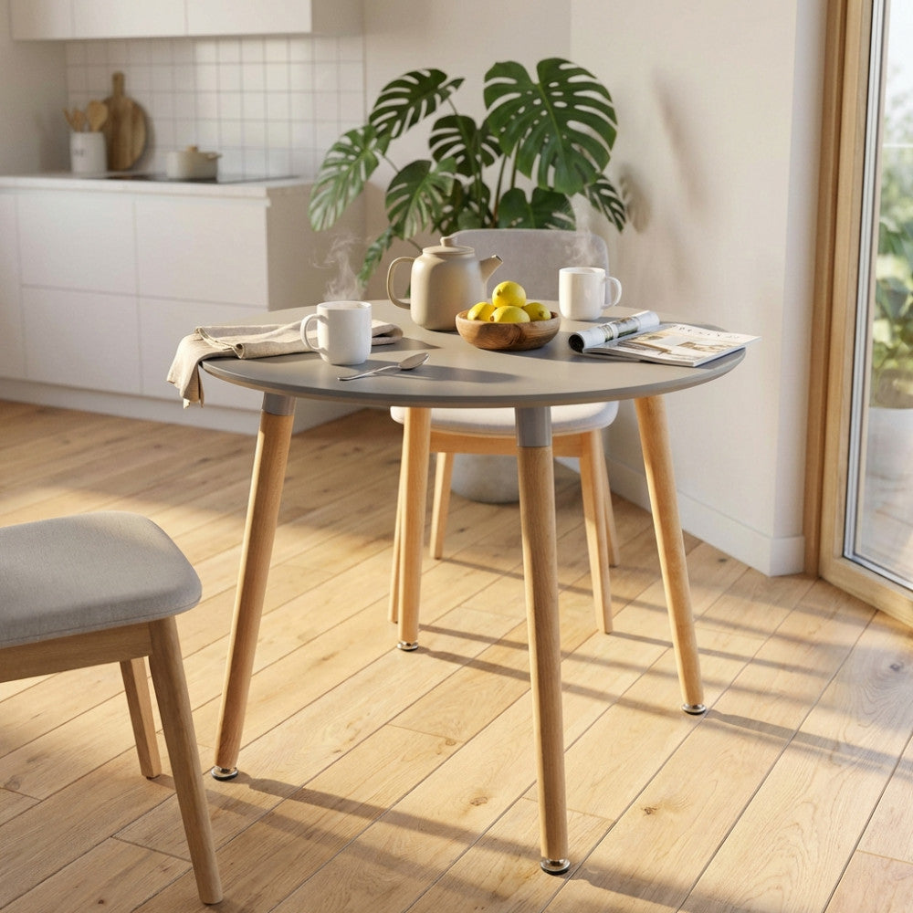 Tavolo da pranzo rotondo Lione grigio allestito in una cucina luminosa con sedie in legno e tessuto.