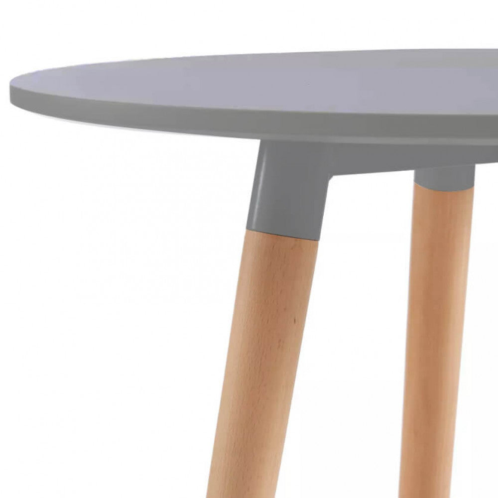 Dettaglio dell'innesto tra il piano grigio del tavolo Lione e le robuste gambe in legno naturale.