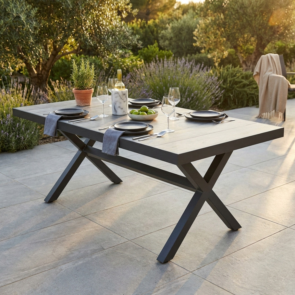 Tavolo da giardino Mackay in alluminio antracite e gres allestito per un pranzo all'aperto.