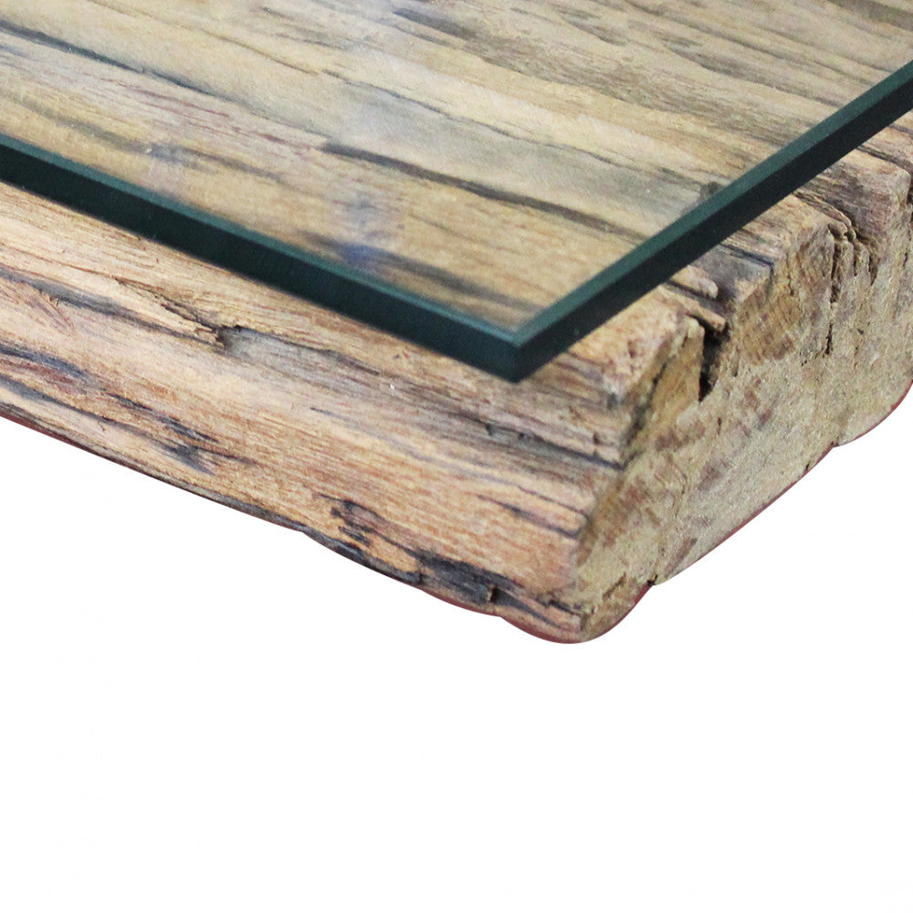 Dettaglio materico del bordo in legno massiccio e della lastra in vetro trasparente.