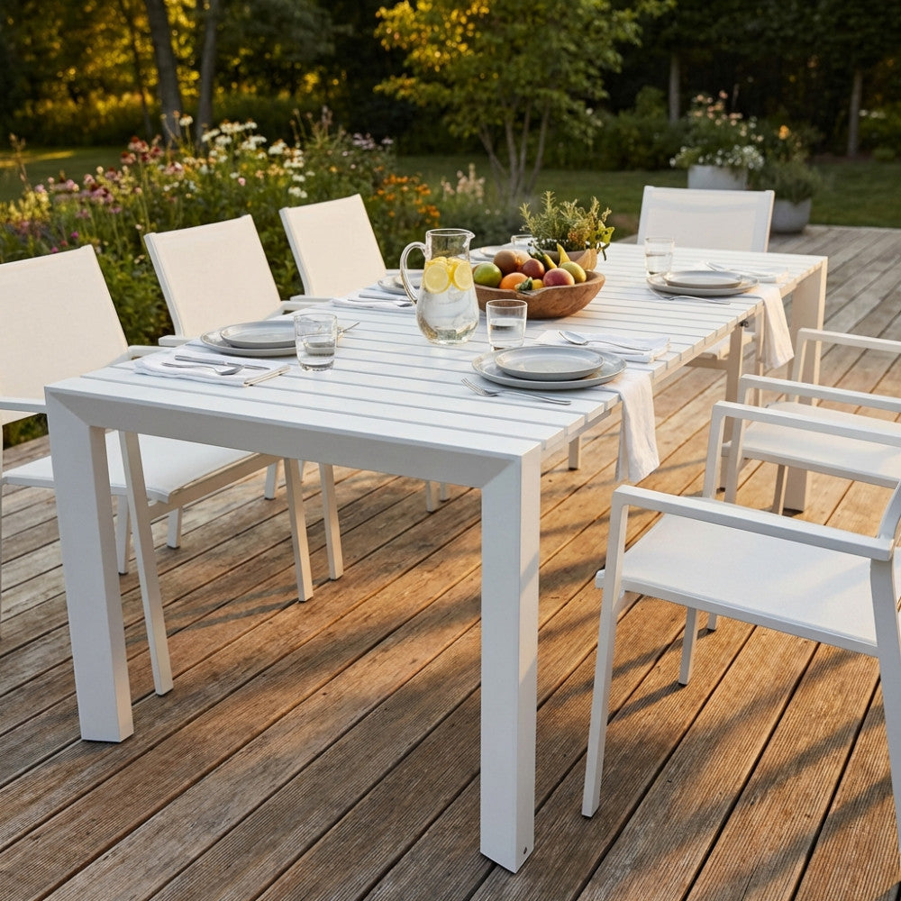 Tavolo da pranzo Nashville bianco allungabile allestito in un giardino lussuoso al tramonto
