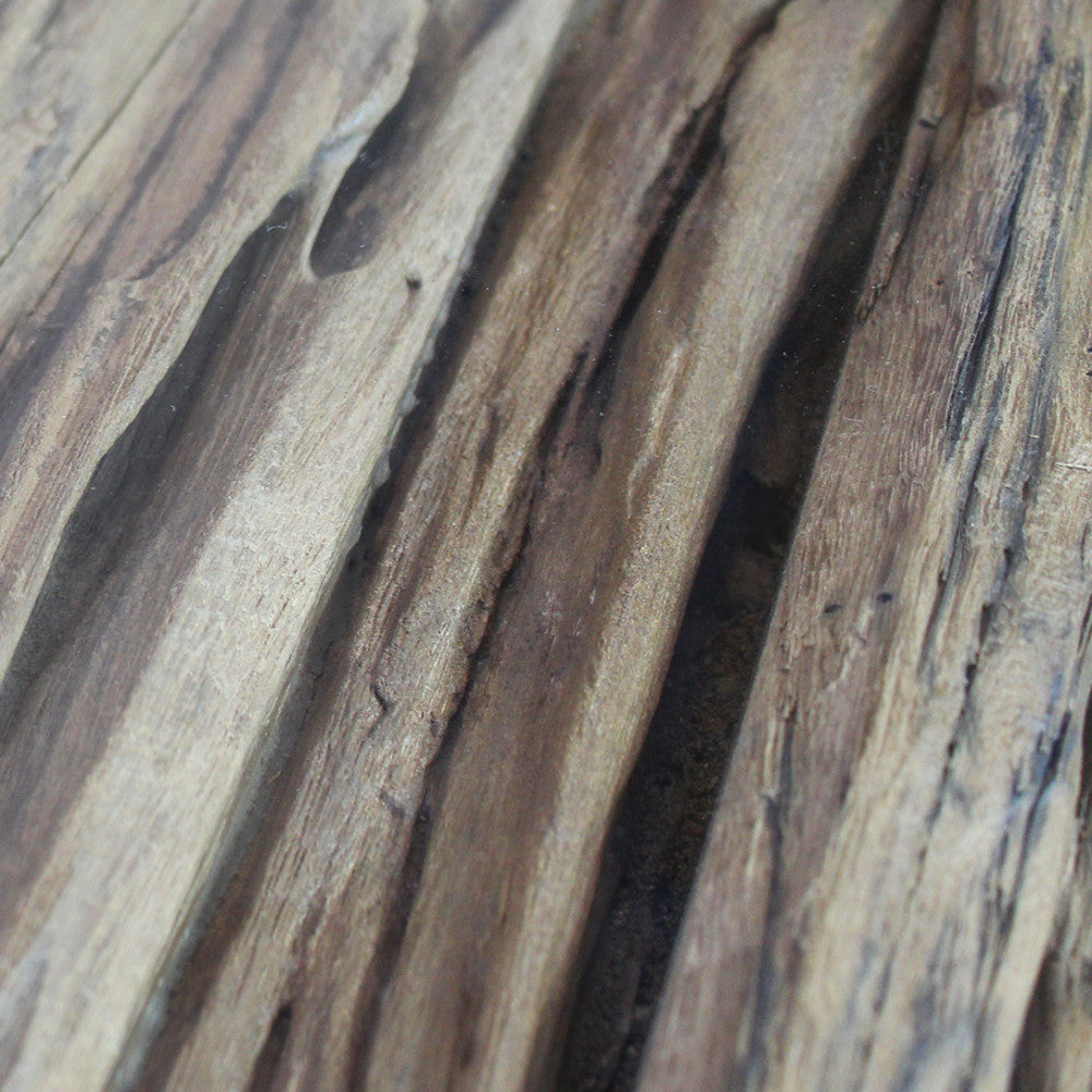 Macro sulle venature profonde e la texture autentica del legno sotto il piano in vetro.