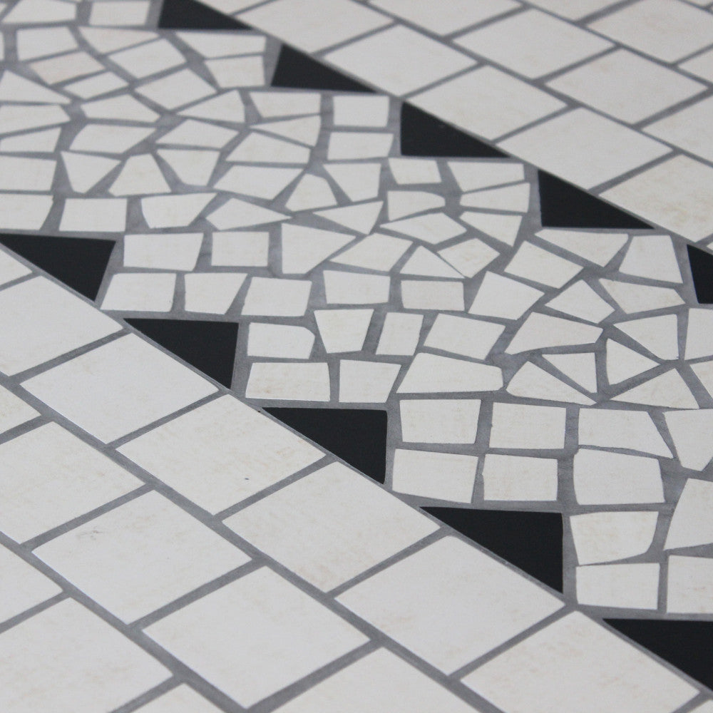 Particolare della lavorazione artigianale del bordo a mosaico con tessere triangolari e quadrate.