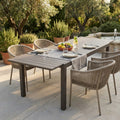 Tavolo da giardino Pental allungabile in alluminio e polywood taupe, allestito per un pranzo all'aperto con sedute in corda.