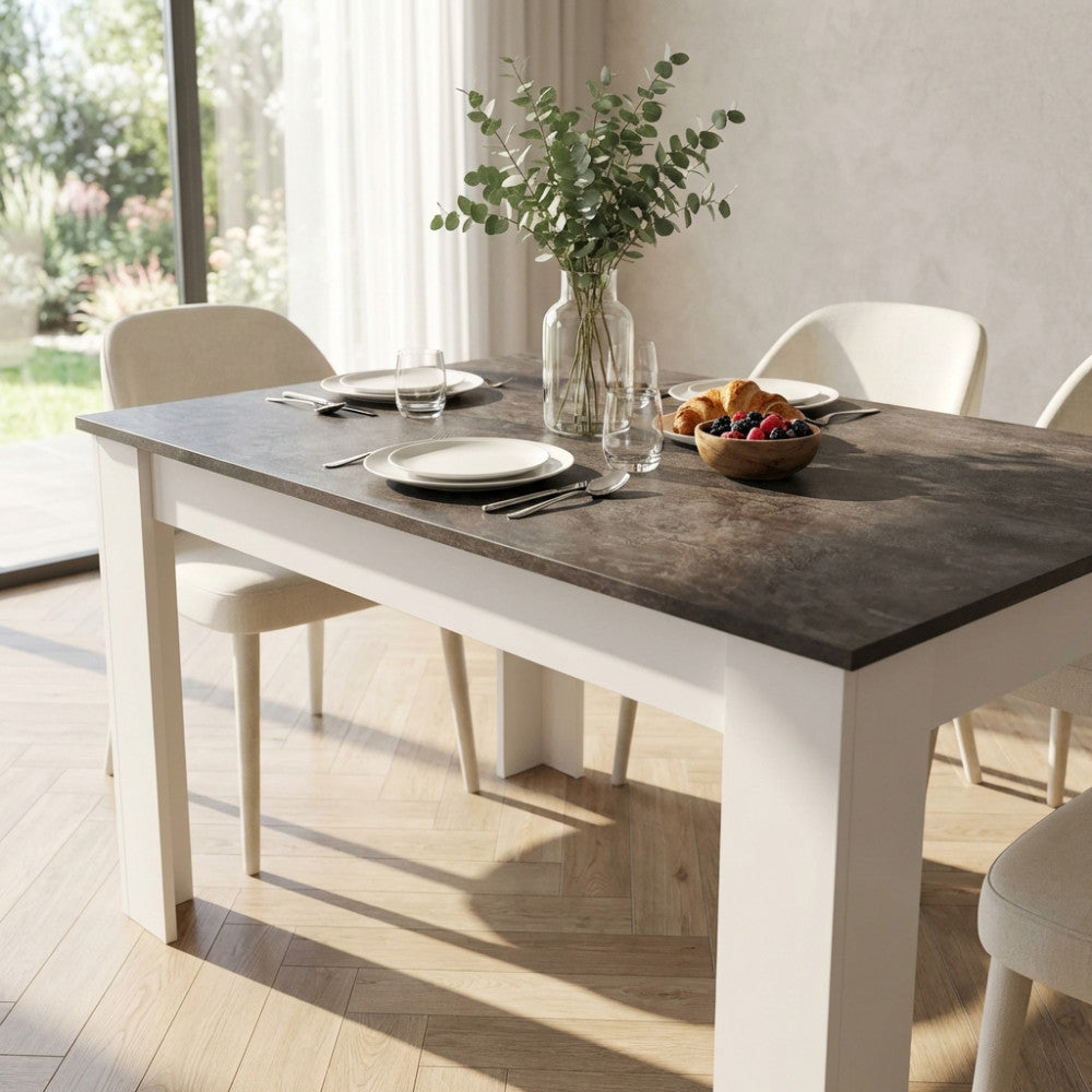 Dettaglio del piano grigio scuro effetto cemento del tavolo Pepper, decorato con vaso di eucalipto e stoviglie.
