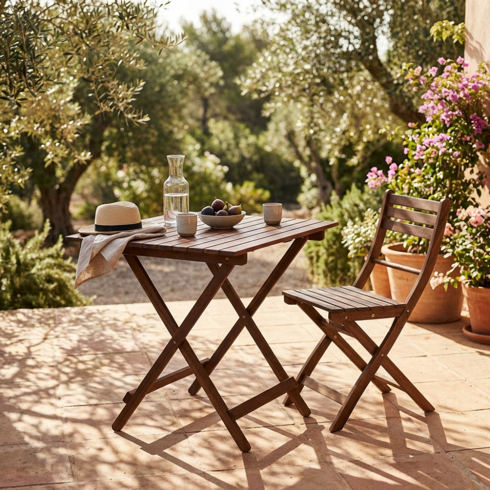 Tavolo da esterno in legno marrone decorato con fichi e brocca d'acqua, circondato da ulivi e vegetazione mediterranea.