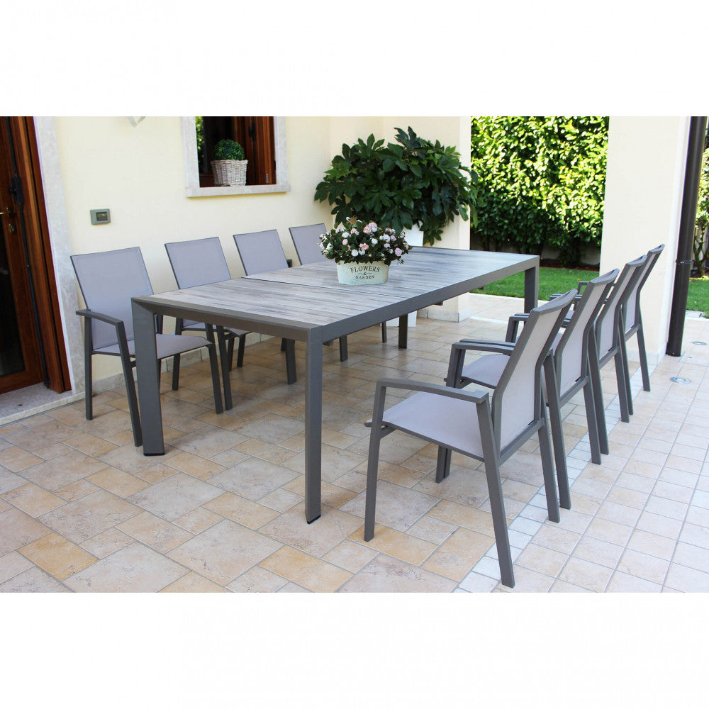 Tavolo Portland esteso a 235 cm, circondato da sedute minimaliste in un patio pavimentato.