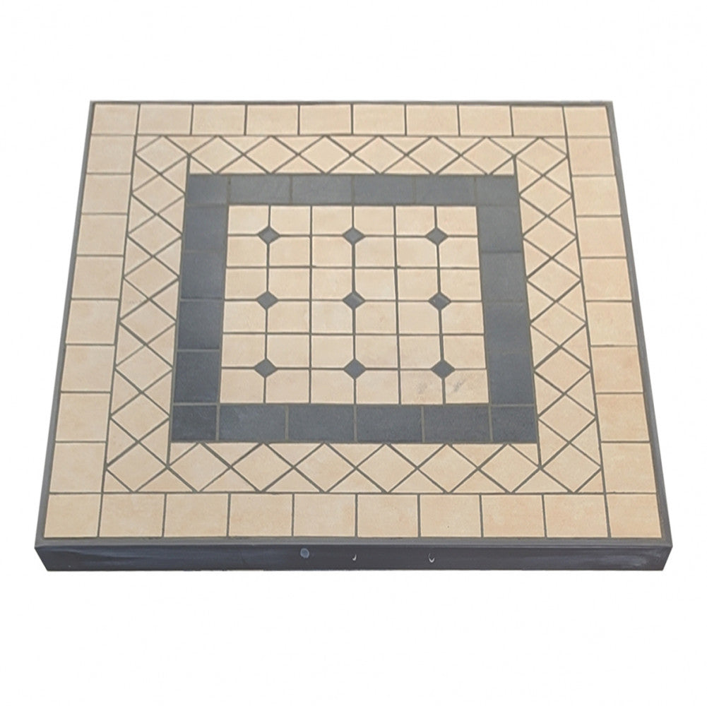 Inquadratura dall'alto del top in cemento del tavolo Nereo, che mostra il pattern geometrico a mosaico nei toni taupe e grigio scuro.