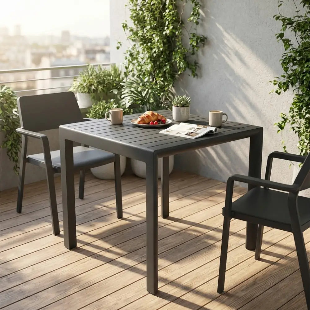 Tavolo da giardino Rosario in alluminio antracite allestito per la colazione su un balcone cittadino.