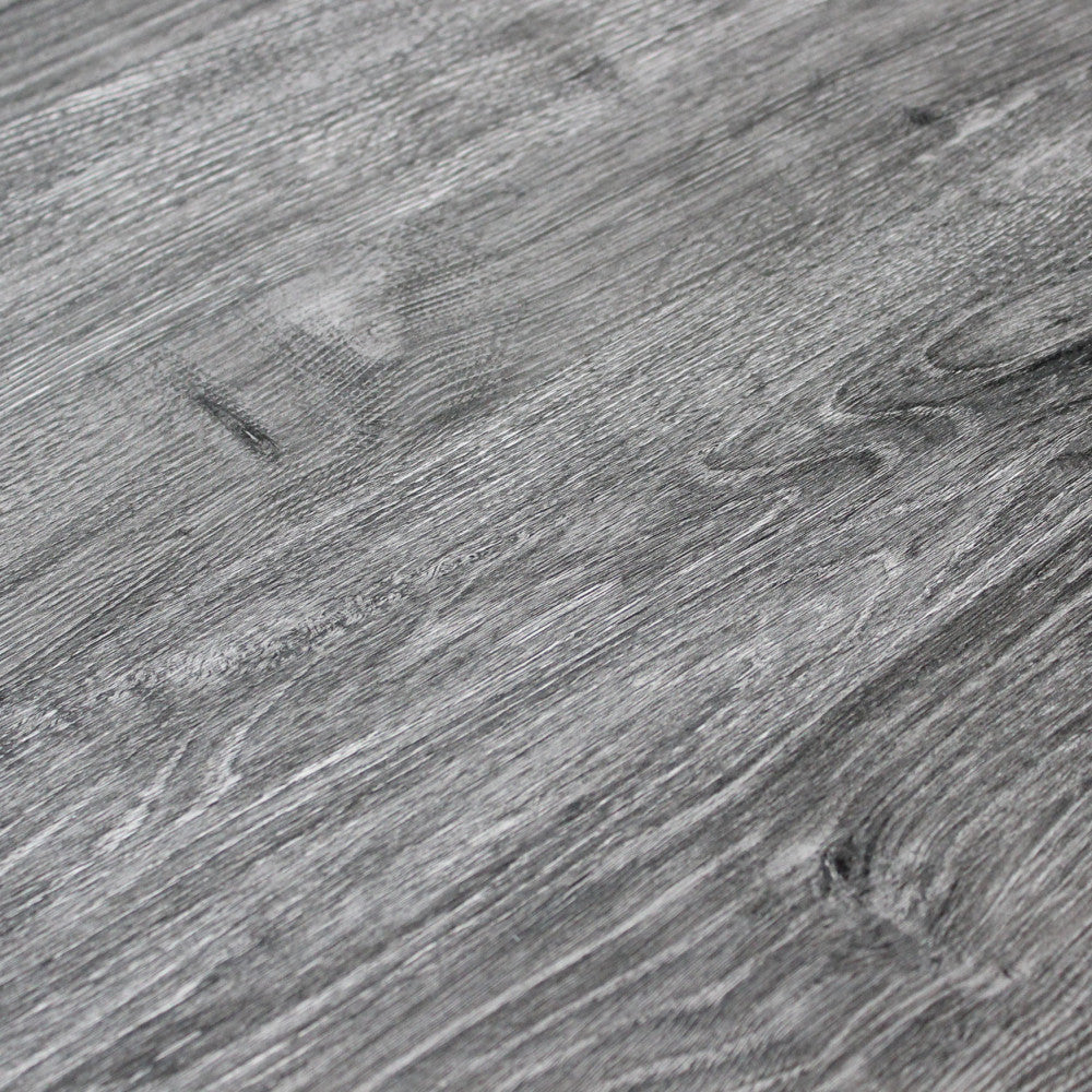Dettaglio ravvicinato della texture del piano del tavolo, mostrando la finitura robusta e le sfumature grigio scuro.