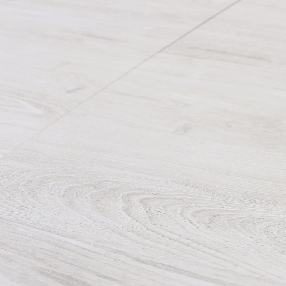 Primo piano della texture in melaminico bianco effetto legno del tavolo Garry, che evidenzia le venature tattili.