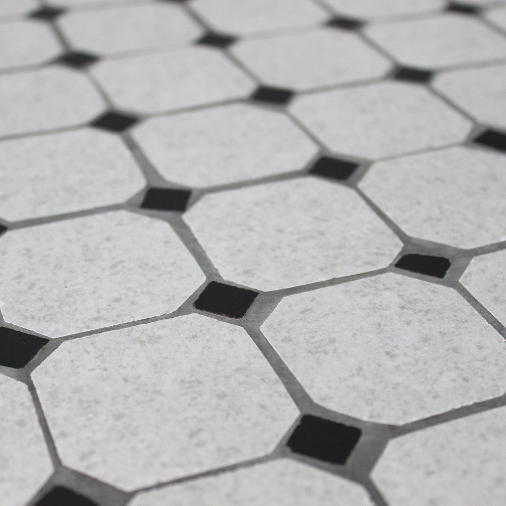 Prospettiva macro della superficie in ceramica del tavolo, che evidenzia la texture materica e le fughe.