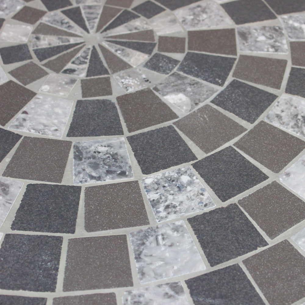 Dettaglio ravvicinato del motivo a mosaico geometrico in ceramica antracite e beige.
