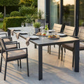 Tavolo da giardino Sacramento in alluminio antracite allestito per una cena all'aperto con sedie abbinate.
