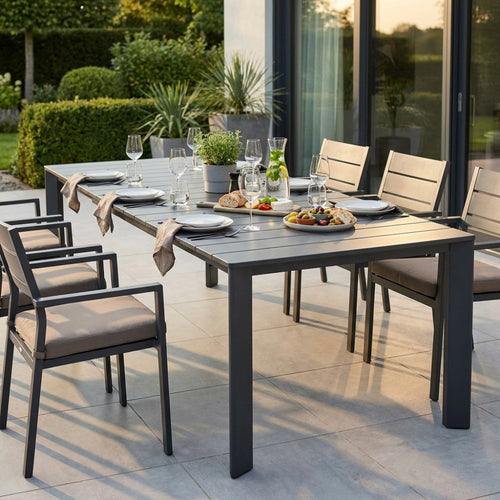 Tavolo da giardino Sacramento in alluminio antracite allestito per una cena all'aperto con sedie abbinate.