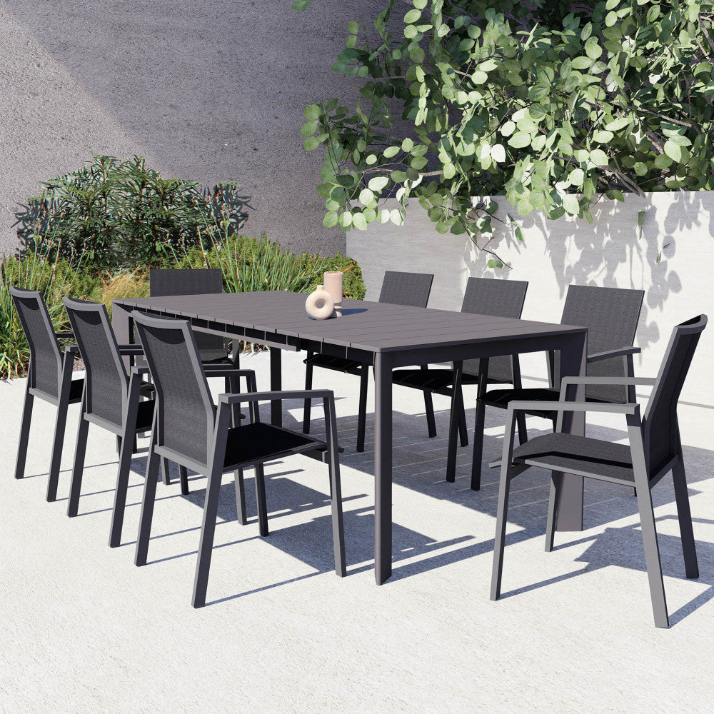 Tavolo Sacramento allestito in un patio moderno con sedie in tessuto tecnico e decorazioni minimaliste.