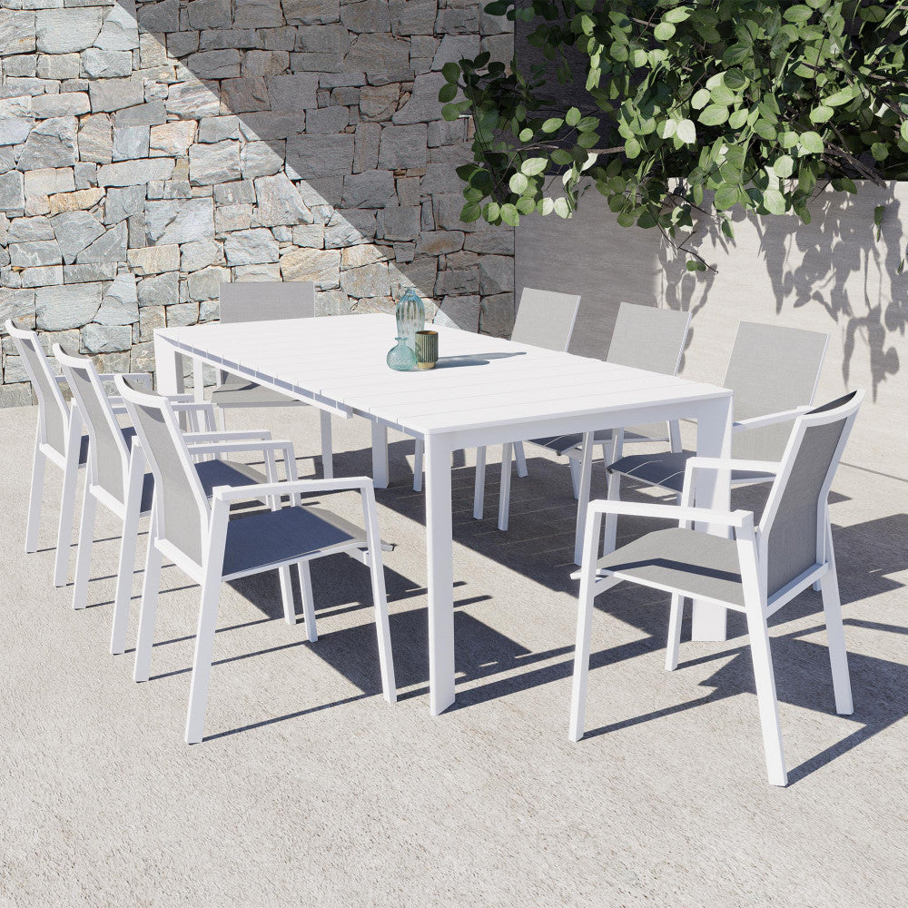 Tavolo Sacramento in alluminio bianco abbinato a sedie moderne in un patio soleggiato.