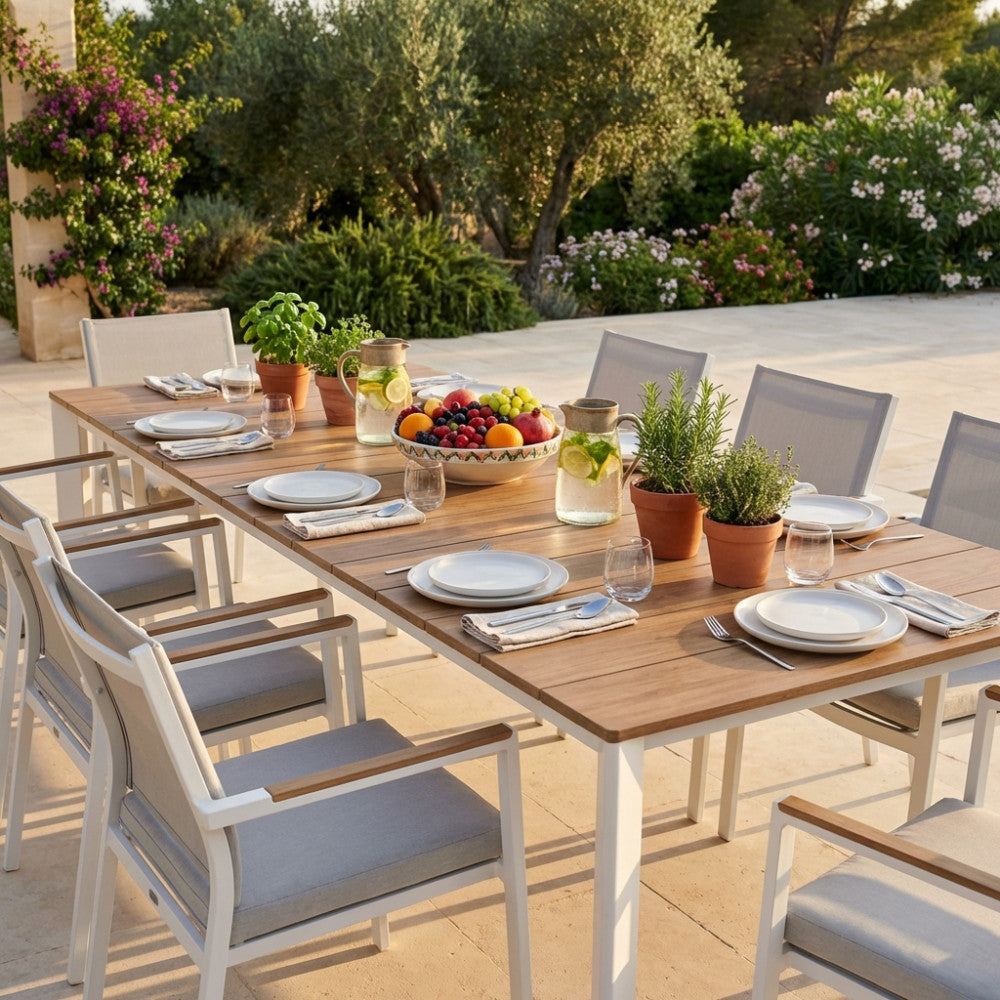 Tavolo da giardino Sacramento allungabile in alluminio bianco, allestito per un pranzo all'aperto con sedute abbinate.