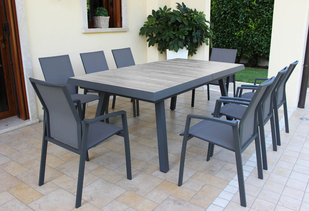 Prospettiva angolare del tavolo da giardino Seattle su un patio elegante con piante decorative.