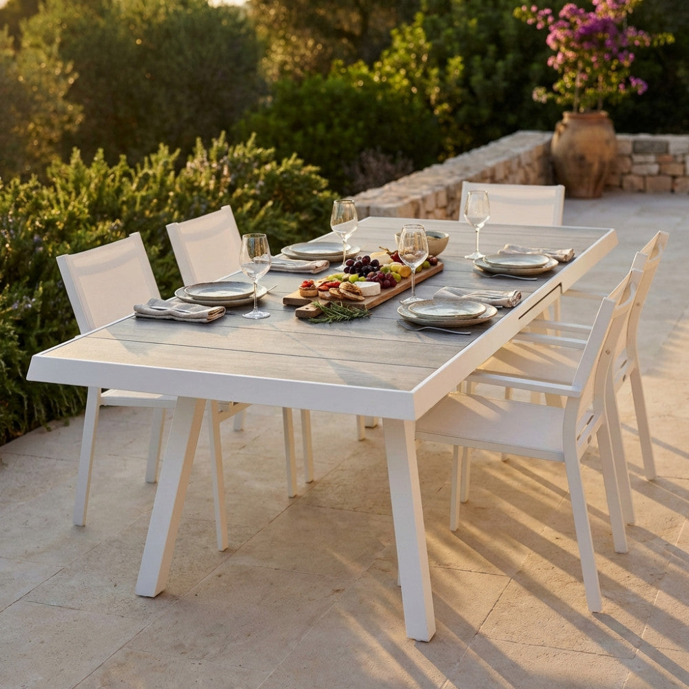 Tavolo da giardino Seattle in alluminio bianco e gres allestito per un aperitivo al tramonto.