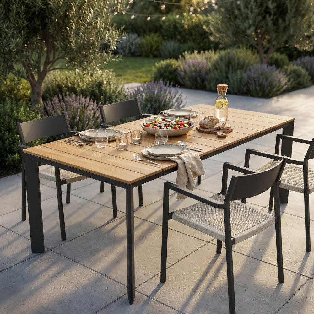 Tavolo da pranzo allungabile in teak Tulcán allestito per un pranzo all'aperto con sedie antracite.