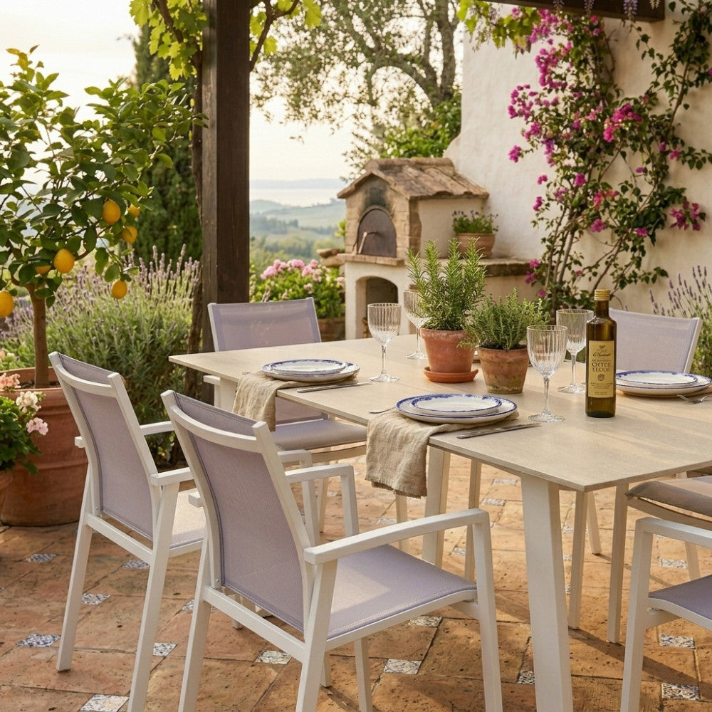 Dettaglio ravvicinato del tavolo da giardino Warren, che mostra la texture della pietra sinterizzata e le sedute abbinate.