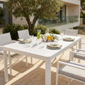 Tavolo da giardino Washington allungabile in alluminio bianco, allestito per un pranzo all'aperto su una terrazza soleggiata.