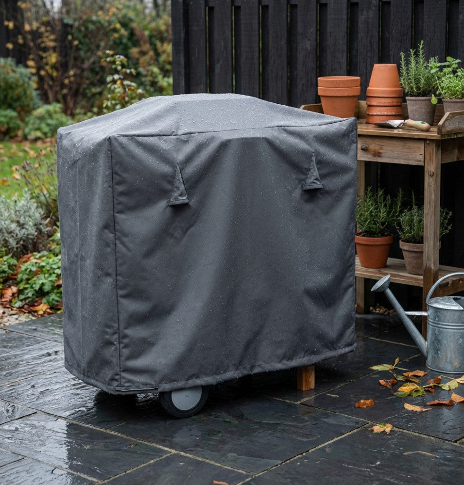 Dettaglio del telo per barbecue sotto la pioggia, che mostra la resistenza dell'acqua sul tessuto.