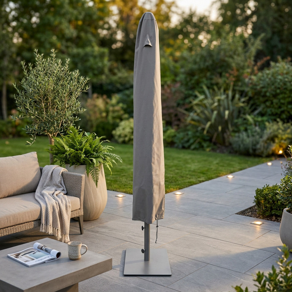 Telo di copertura per ombrellone in tessuto antracite ambientato in un giardino elegante con arredi moderni.
