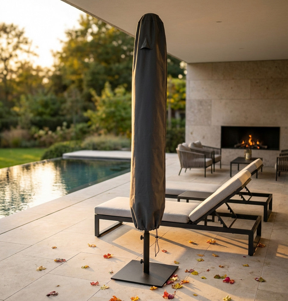 Telo di copertura per ombrellone in tessuto antracite posizionato a bordo piscina al tramonto, accanto a lettini dal design moderno.