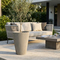 Vaso Grande Iris in fibra sintetica antracite con ulivo su patio in pietra chiara.