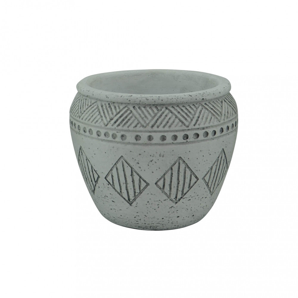 Vista angolata del vaso geometrico grigio su sfondo neutro, mostrando la texture porosa e la robustezza del materiale.