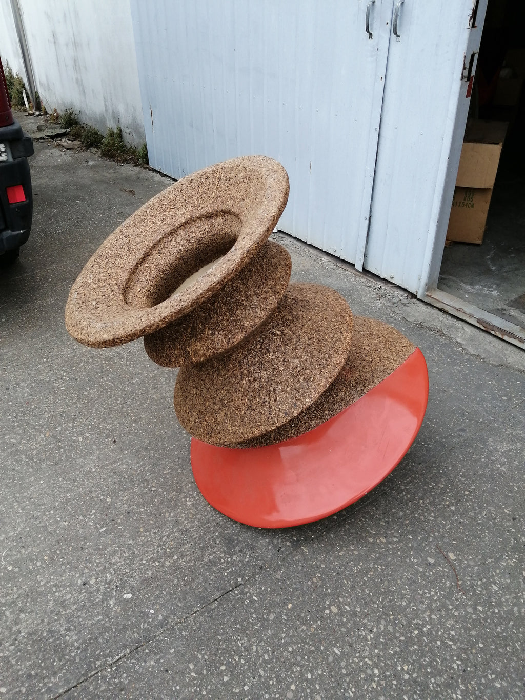 Vaso ornamentale arancione in truciolato pressato.