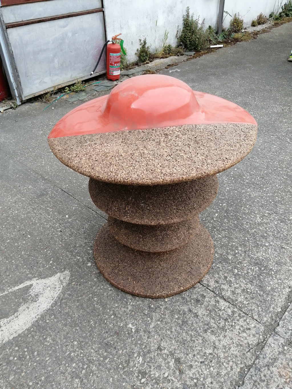 Vaso ornamentale arancione in truciolato pressato.